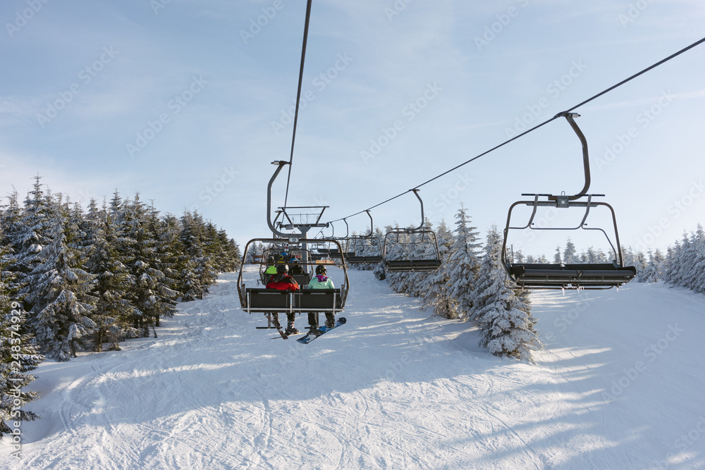 Ski lift with people at ski resort. Sunny day Ski lift with people at ski resort. Sunny day