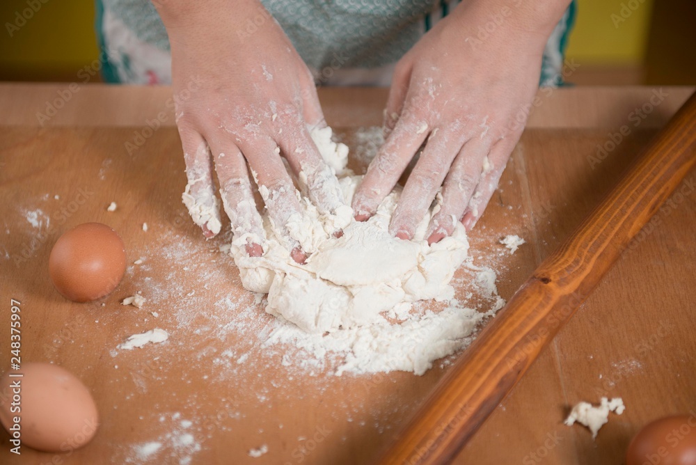 close up scene of female hands making dough