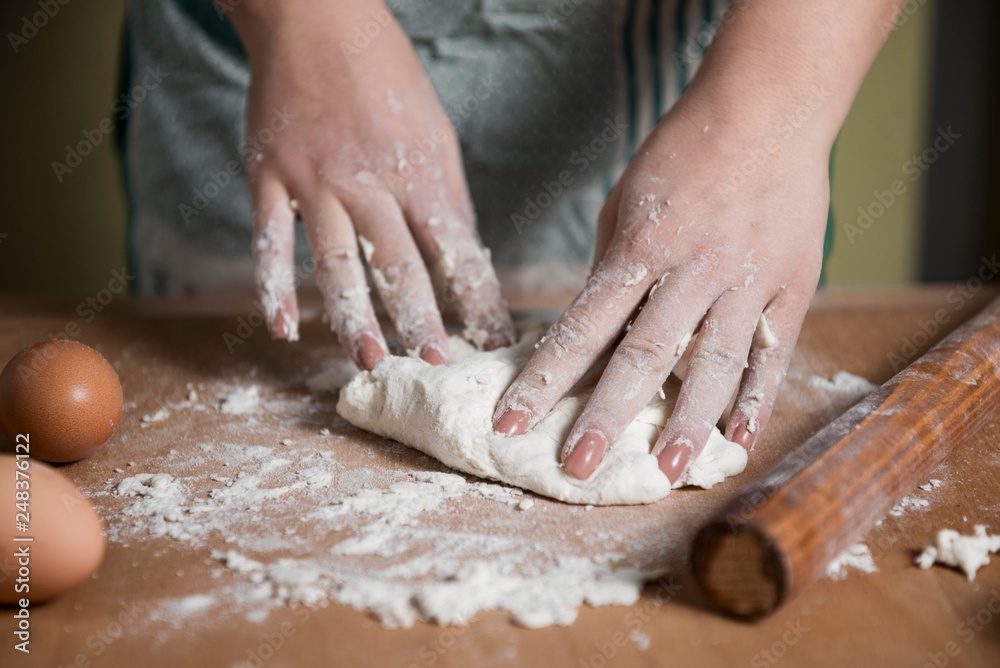 close up scene of female hands making dough