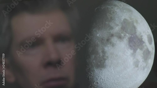 Reflection of a caucasian man looking at the moon on a screen themes of astronomy science global earth space  - Created with public domain images from Nasa