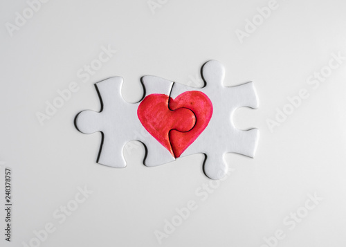 Love puzzle. Pieces of a puzzle with half of a red heart drawn on each piece, fitting perfect together.
