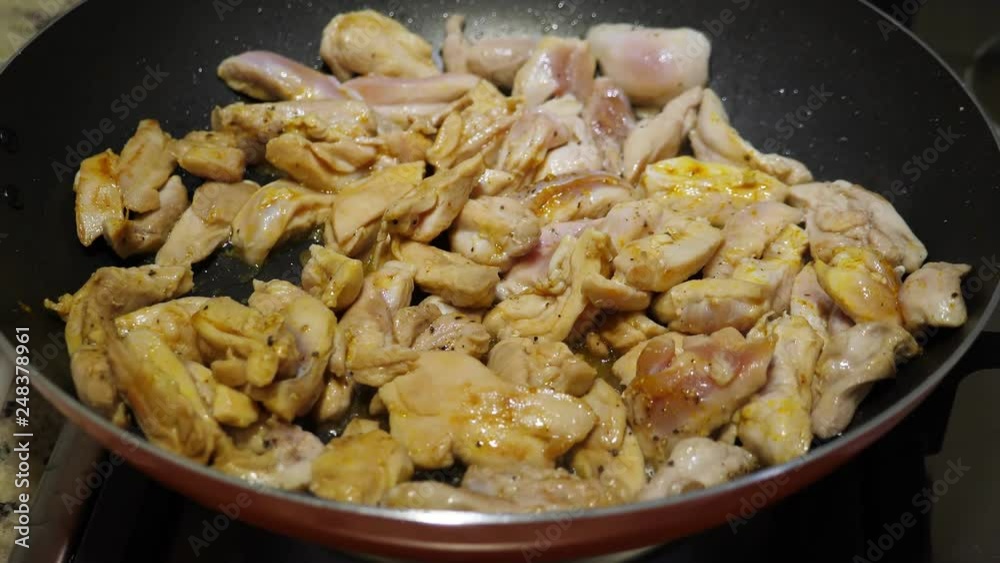 Cooking chicken breast on frying pan, closeup Cooking chicken breast on frying pan, closeup
