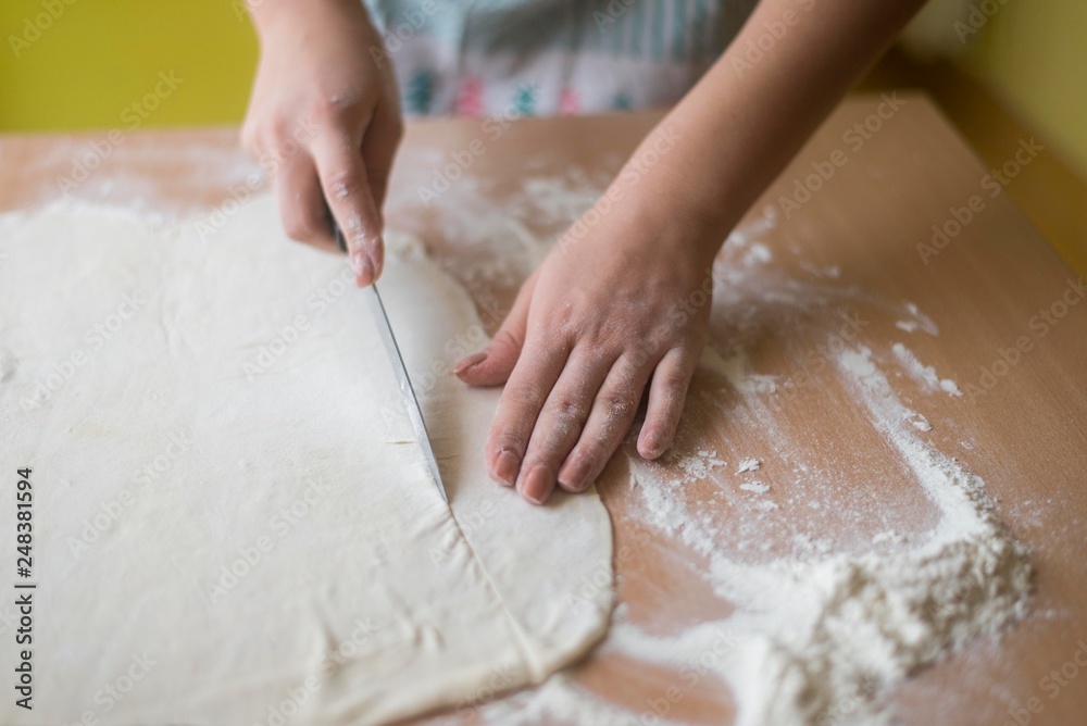 female hands cutting daugh with knife. bakery sweets. female hands cutting daugh with knife. bakery sweets.