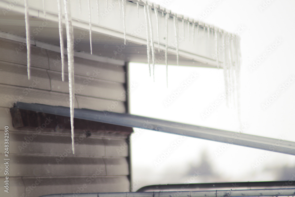 Icicles in the winter on roof of small building