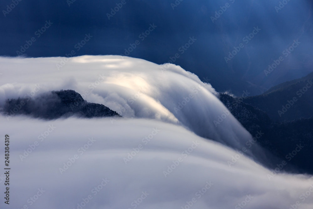 Cloud Waterfall, Abstract landscape image - Mountains and Valleys, Soft Fluffy clouds spilling over a mountain ridge into the valley below. Soft ghostly blue lighting, artistic nature photography Cloud Waterfall, Abstract landscape image - Mountains and Valleys, Soft Fluffy clouds spilling over a mountain ridge into the valley below. Soft ghostly blue lighting, artistic nature photography