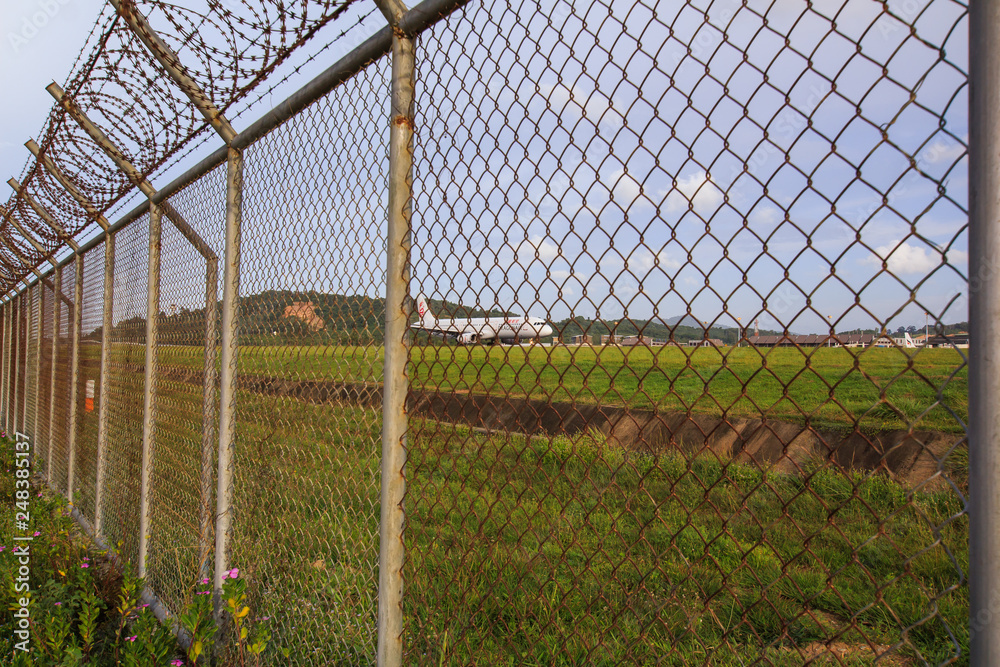 Chain link fence with grass field Phuket International Airport Chain link fence with grass field Phuket International Airport