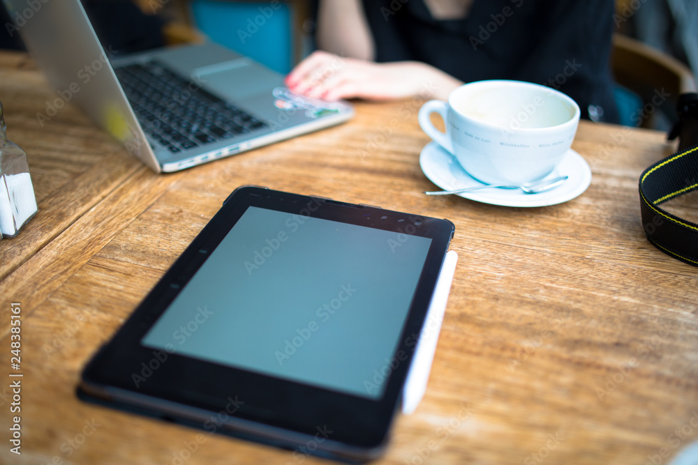 young adult businessperson working on laptop with coffee pro pad and pencil on the table young adult businessperson working on laptop with coffee pro pad and pencil on the table