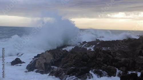 Huge waves break on the stones, slow motion