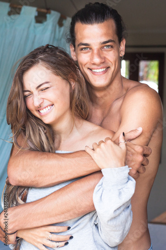 young attractive handsome smiling man and woman hugging in the room