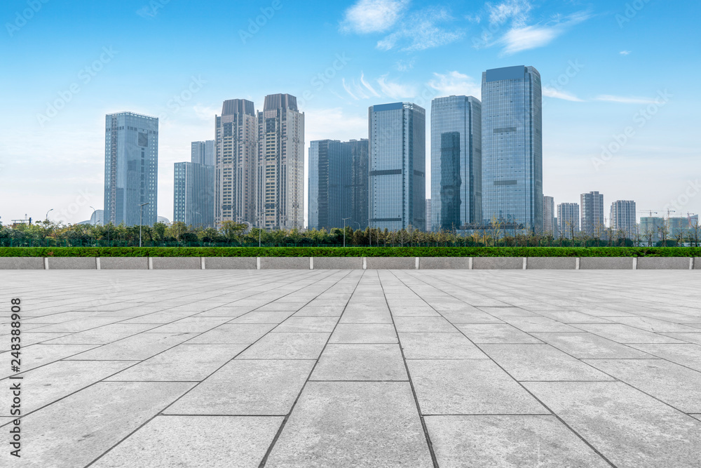 Empty Plaza floor tiles and the skyline of modern urban buildings in Hangzhou..