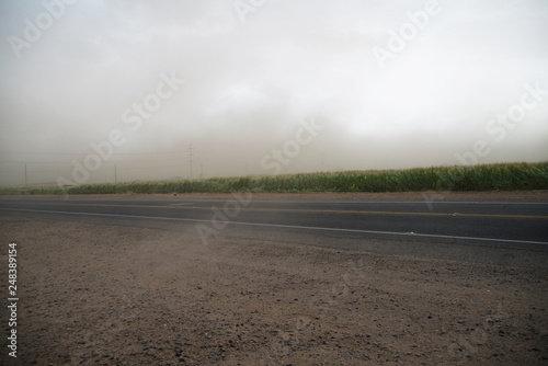 road in field with blue sky and clouds