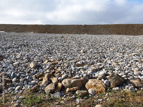 Looks like a sea of ​​stones in front of a mound of earth. photo