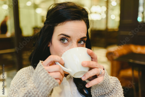 Pretty brunette woman drinking coffee in Vienna, European city, during a trip.