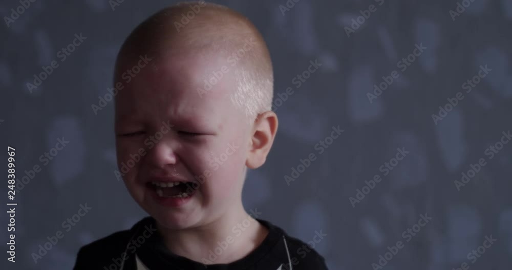 Concept of emotion. Little blond boy suddenly burst into tears. Child cry and can not calm down and confused.