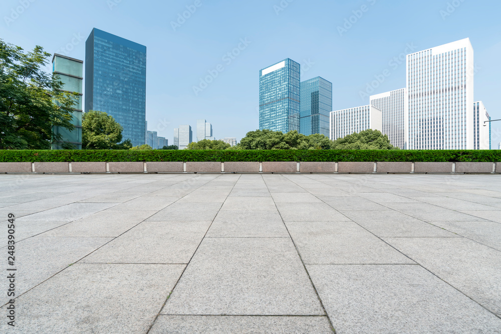 Empty Plaza floor tiles and the skyline of modern urban buildings in Hangzhou..