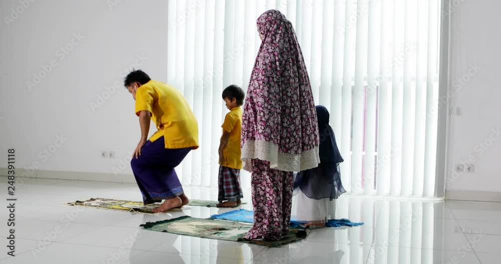 Religious muslim family with two children praying together at home. Shot in 4k resolution