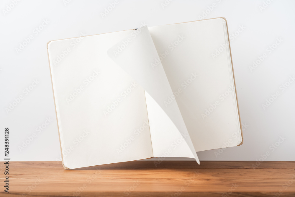 Perspective view of kraft notebook on wood floor Perspective view of kraft notebook on wood floor