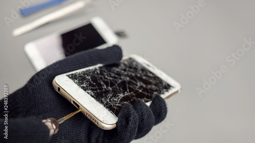 Foto Technician or engineer opening broken smartphone for repair or replace new part