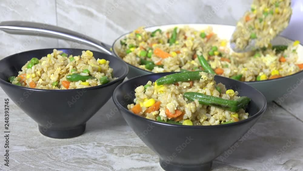 Serving fresh cooked fried rice in bowls Serving fresh cooked fried rice in bowls