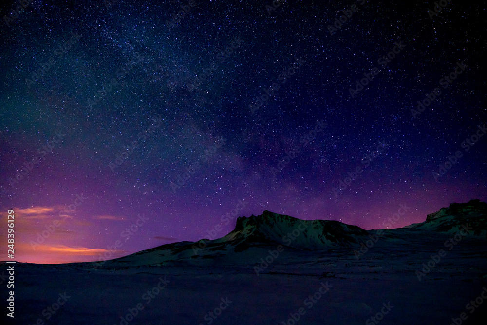 Starry sky at dusk by a mountain