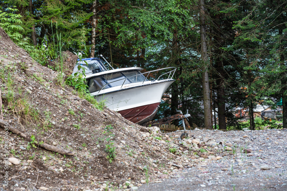 The boat floats because of the turn on a dirt road in Altai, Russia The boat floats because of the turn on a dirt road in Altai, Russia