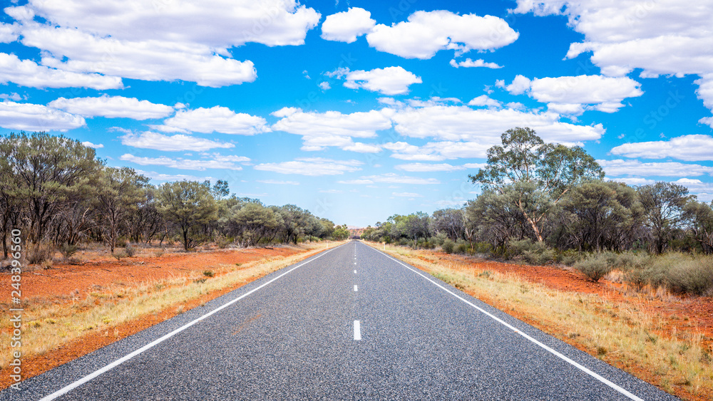 Straight road with white lines in middle of outback red centre Australia