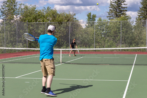 father and young son having tennis match on the courts © nat2851terry