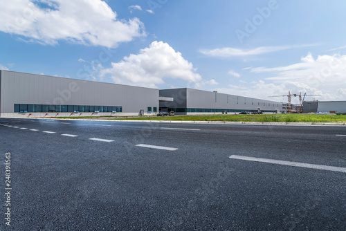 Fototapeta Naklejka Na Ścianę i Meble -  Road asphalt pavement and modern factory warehouse..