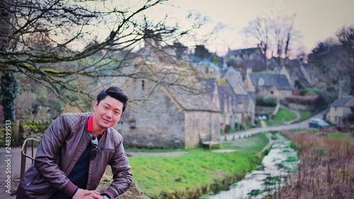 Asian man with Bibury villages in background, UK, England