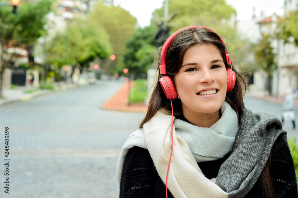 Portrait of young beautiful woman with red headphones listening music Portrait of young beautiful woman with red headphones listening music