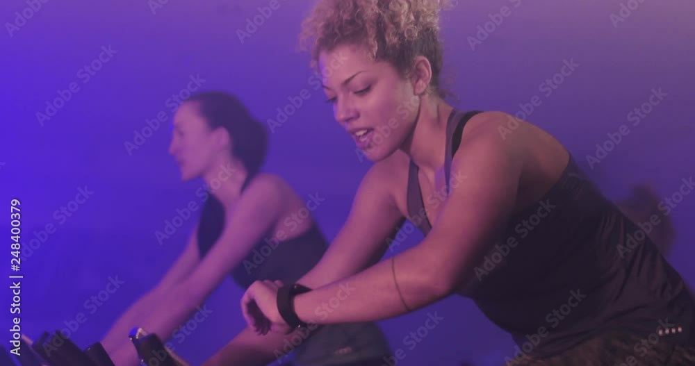 Woman in spinning class checking fitness tracker