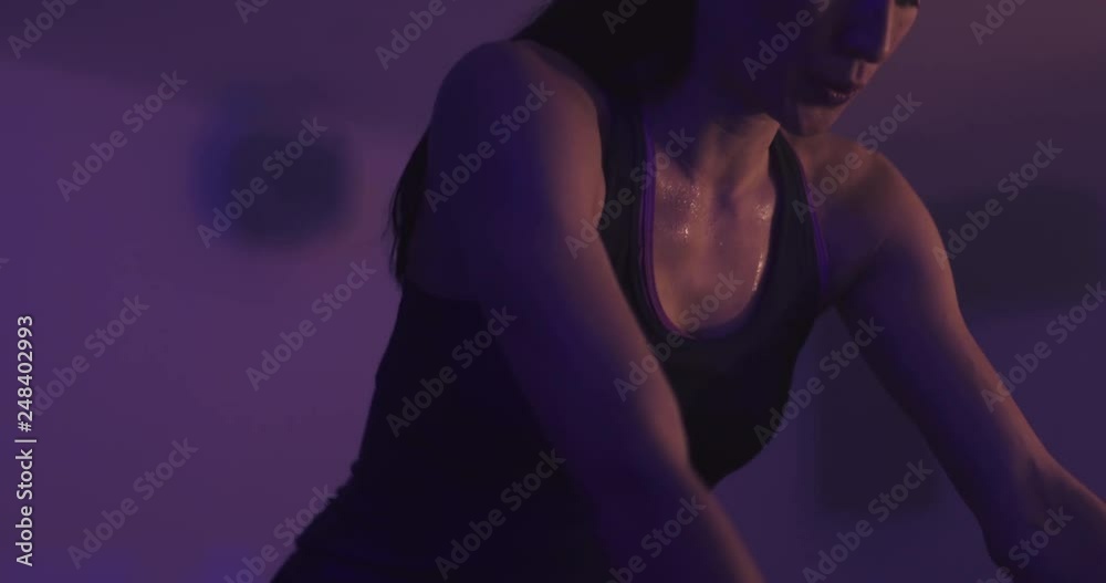 Woman in spinning class with lights and effects