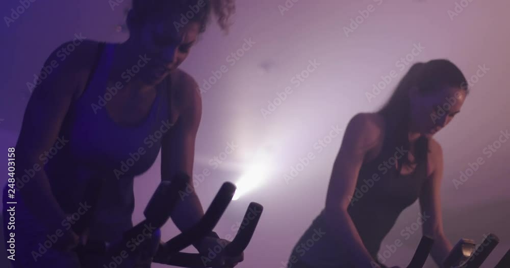 Woman in spinning class with lights and effects
