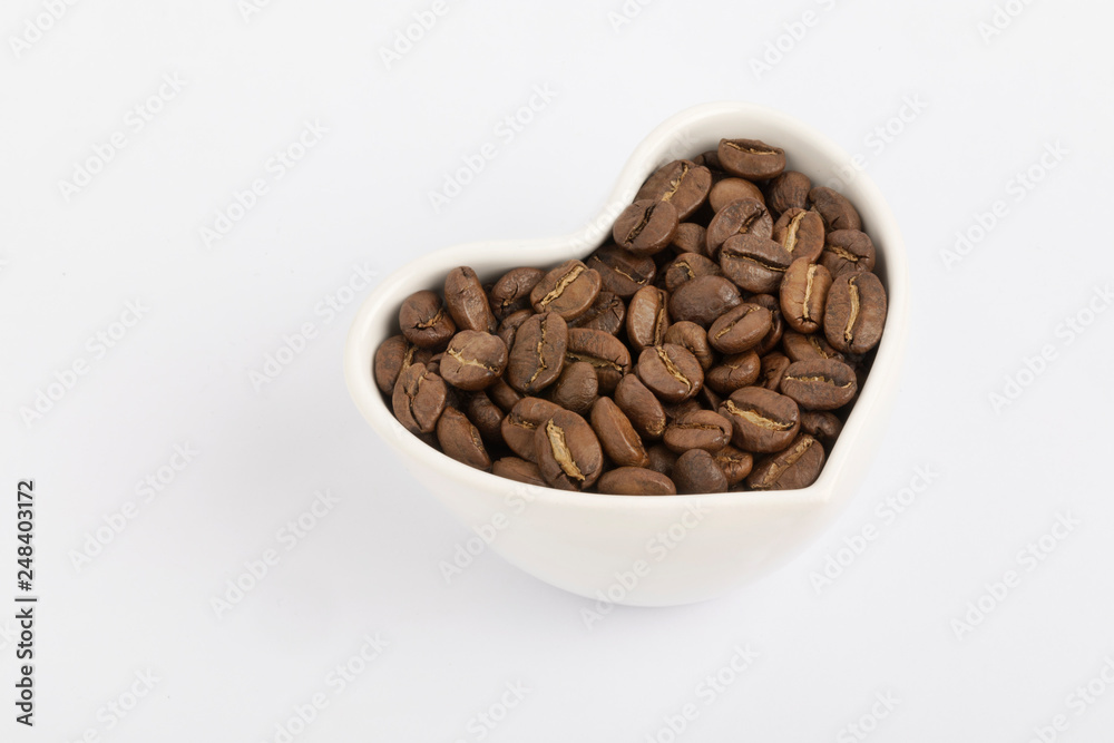 Fototapeta premium Ciotola a forma di cuore con chicchi di caffè