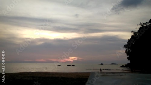 Time lapse sunset on the beach, bay, people walk along the shore. Siluety. photo