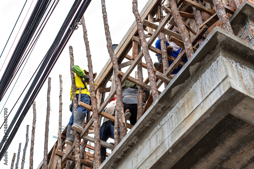 workers working for a new home building with wood scaffolding workers working for a new home building with wood scaffolding