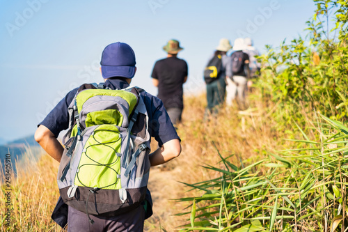 Group of friends climbing mountain with backpacks. Selective focus