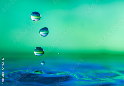 close up of a water drop falling impacting a body of water