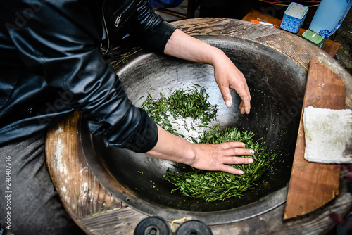Traditional tea making Drying green tea in pan processing by hand at Longjing Village in Hangzhou China.