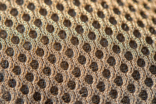 Golden dotted texturised technological seamless fabric or surface closeup