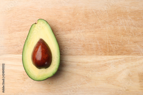 half avocado on wooden background top view
