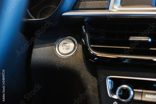 Car dashboard, start button, chrome design elements of a modern car