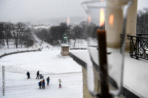 View from the Royal Palace on Statue of King Karl Johan and  Oslo city center, Norway. 28-01-2019 Сandle burns on the windowsill in the palace. photo