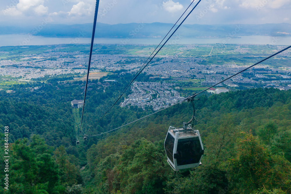 Cable cars traveling up Mount Cangshan with view of Dali, Yunnan, China