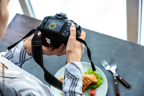 Young woman taking picture of food in professional studio