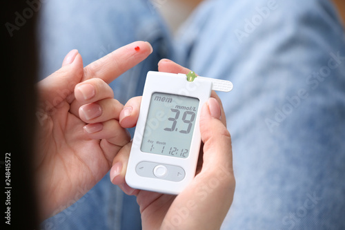Photos Diabetic woman using digital glucometer, closeup