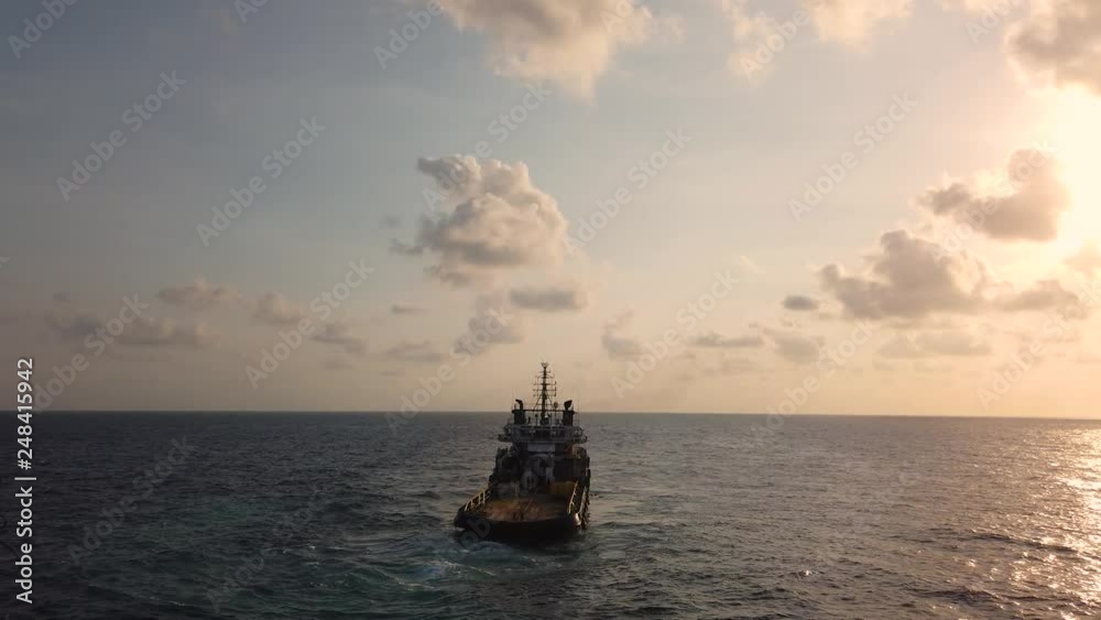 Anchor handling vessel pulling an anchor and wire to move an oil drilling rig in the middle of the ocean Anchor handling vessel pulling an anchor and wire to move an oil drilling rig in the middle of the ocean