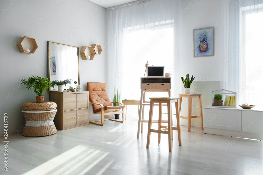 Stylish interior of room with laptop on high wooden table Stylish interior of room with laptop on high wooden table