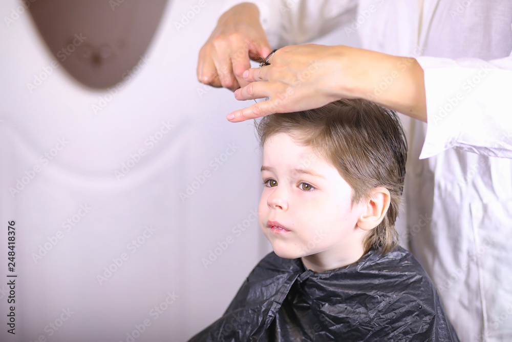 Hairdresser and boy. The boy is doing his hair. Cut hair child in the hairdresser. Hairdresser and boy. The boy is doing his hair. Cut hair child in the hairdresser.