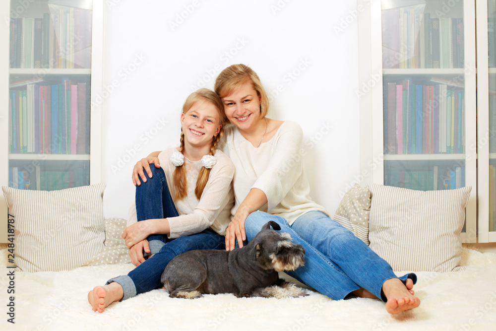 Mother with her 10 years old kid girl sitting home, casual lifestyle photo series. Cozy homely scene.